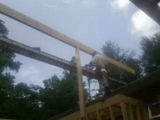 Carpenter setting a ridge beam over a new addition frame — Ice Dam Removal by Roofing Brothers in Bergen