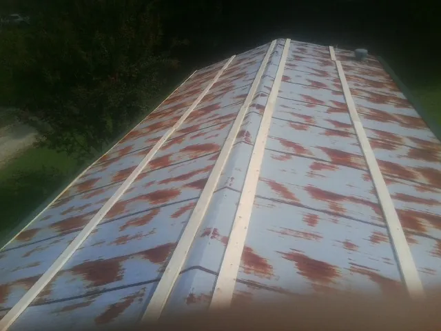 Rusted metal roof panels with new wood purlins before replacement — Storm Damage Roof Repair in Bergen by Roofing Brothers