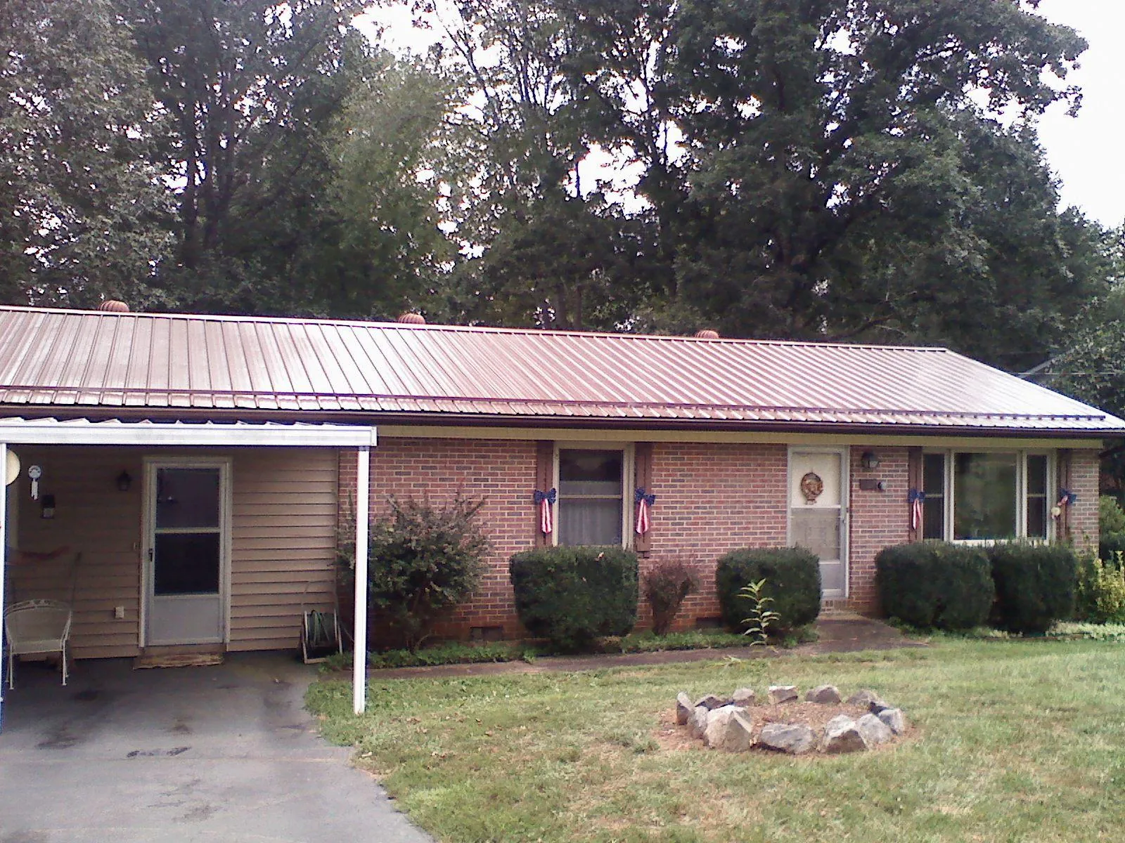 Bronze metal roof and carport on a brick ranch home — Roof Repair work by our crew in Bergen